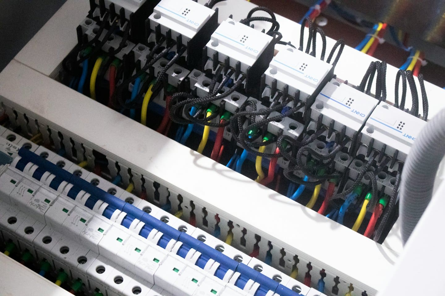 Electrical control panel with circuit breakers and colorful wires.